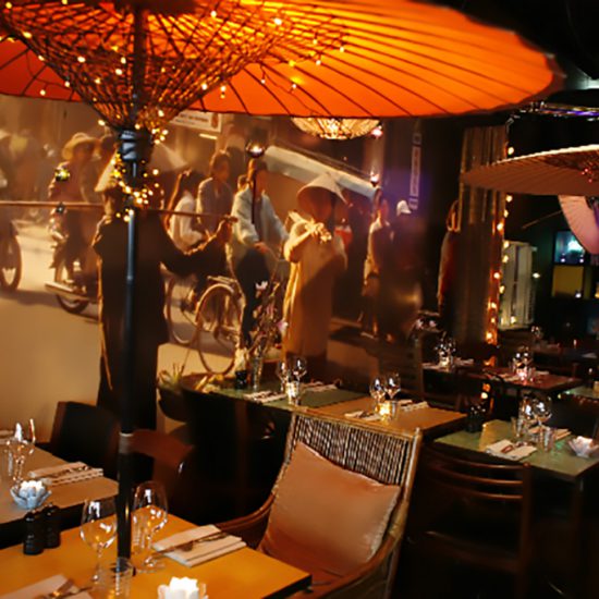 Restaurang möbler och inspiration från indokina med en stor målning från Saigon i bakgrunden
