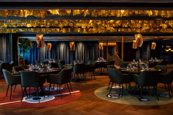 Festsal på restaurang med ett helt tak av sjögräs i mässing designad så att indirekt ljus bjuder in dig.
